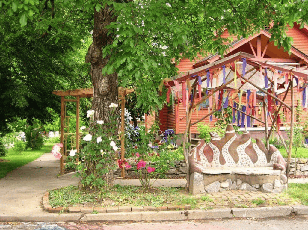 Colorful community art installation in a lush green garden setting.