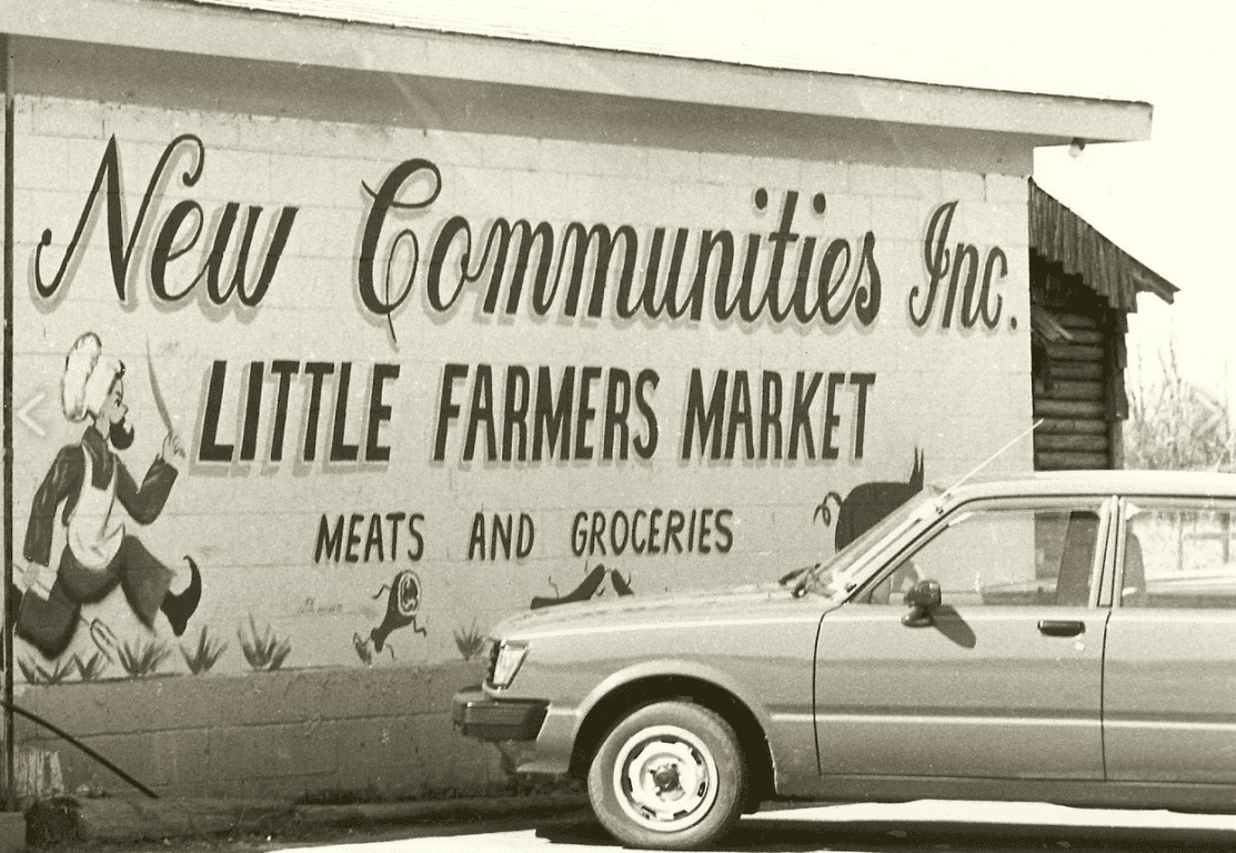 Vintage black and white photo of Little Farmers Market sign and car.