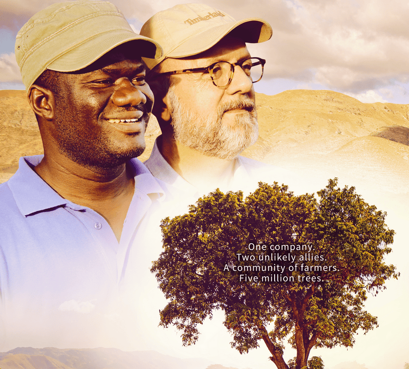 Two farmers smiling outdoors with a tree and landscape in the background.