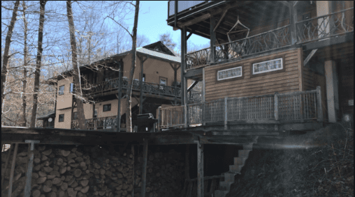 Eco-friendly community houses built on a hillside with wooden decks and stairs.