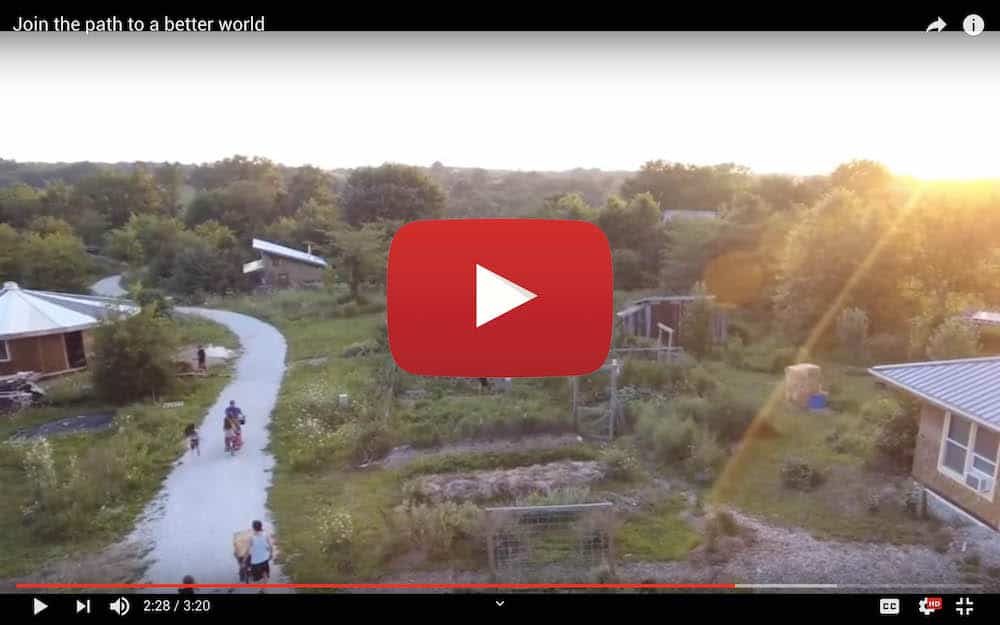 Scenic view of intentional community with pathways and houses at sunset.