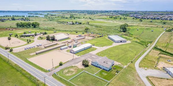 Aerial view of Wild Life Ranch with open fields, buildings, and roads.