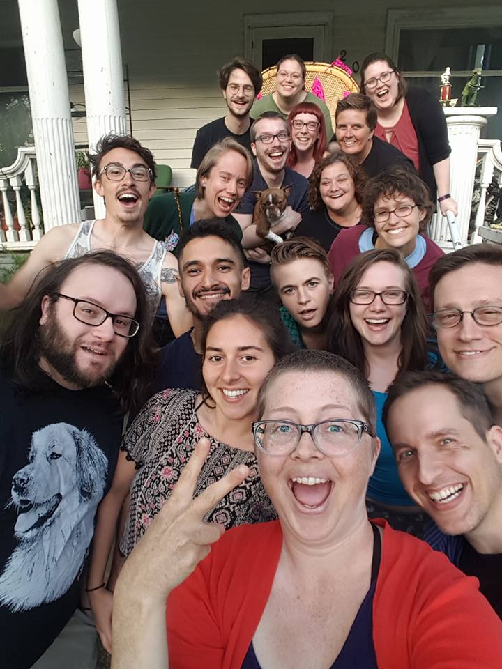 Group of diverse people smiling on a porch at Foundation for Intentional Community event.