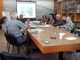 Group of people in a meeting room discussing community projects.