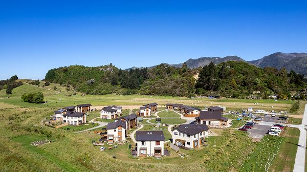 Aerial view of cohousing community with modern homes and green landscape.