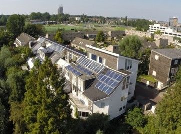 Modern eco-friendly residential buildings with solar panels in a community setting.