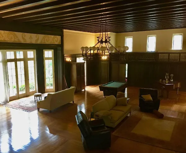 Elegant living room with vintage furniture and large windows for natural light.