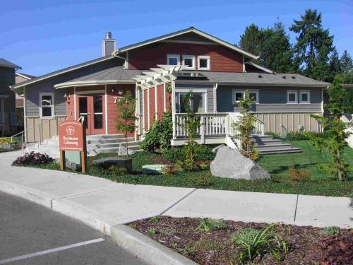 Colorful community house with garden and sidewalk in front.