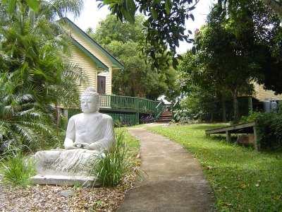Serene garden scene with Buddha statue and lush greenery at Foundation for Intentional Community.