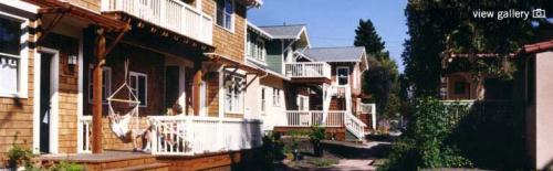 Cozy community homes with wooden decks and lush greenery in Berkeley Cohousing.