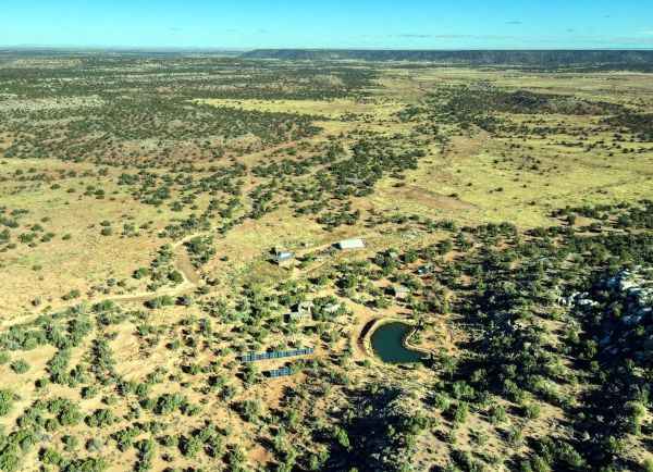 Aerial view of Coslor Cove off-grid community with gardens and water features.