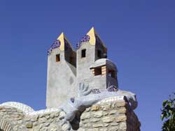 Unique white building with colorful accents and tower structures under a clear blue sky.