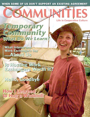 Smiling woman in a hat at a community event, holding a box.
