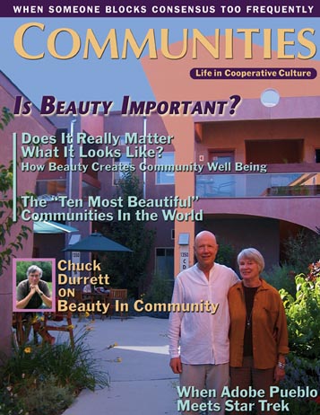 Two seniors standing outside a colorful community building with lush greenery.