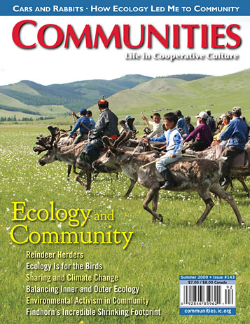 Community members riding donkeys in a green field with hills in the background.