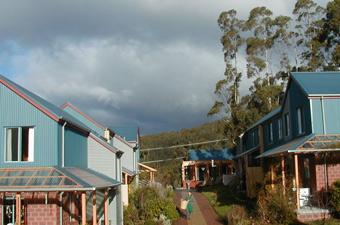 Eco-friendly community housing with blue roofs and lush greenery.