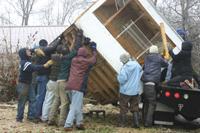 Group of people building a tiny house at Foundation for Intentional Community event.