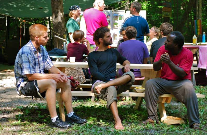 People gathered outdoors at a community event during the Twin Oaks Conference.