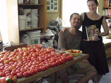 People in a community kitchen with fresh tomatoes and apples for a project.