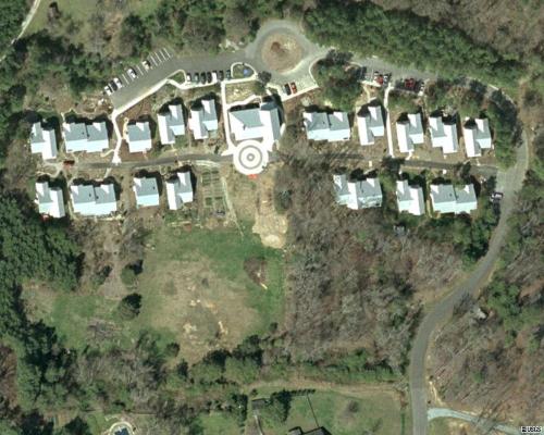 Aerial view of a community with multiple houses and green spaces at Foundation for Intentional Comun.