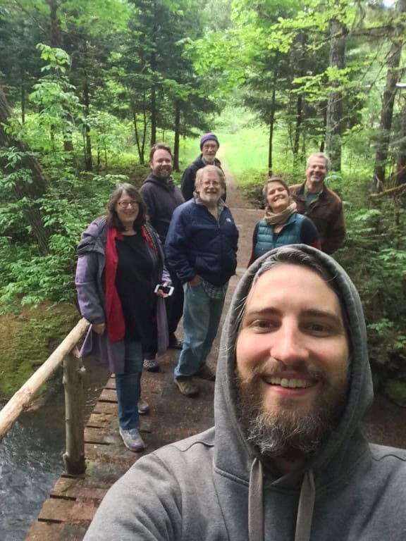 Group of people enjoying a walk in a lush green forest.