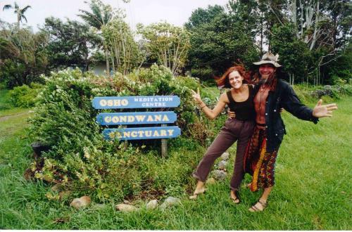 People standing near a sign for Gondwana Sanctuary and Osho World Meditation Centre.