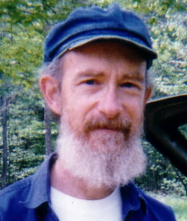 Portrait of a man with a beard and blue cap outdoors at Foundation for Intentional Community.