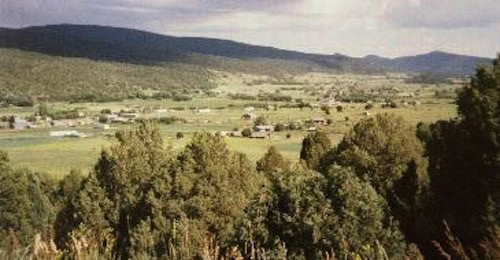 Scenic view of rural landscape with hills and trees in the foreground.