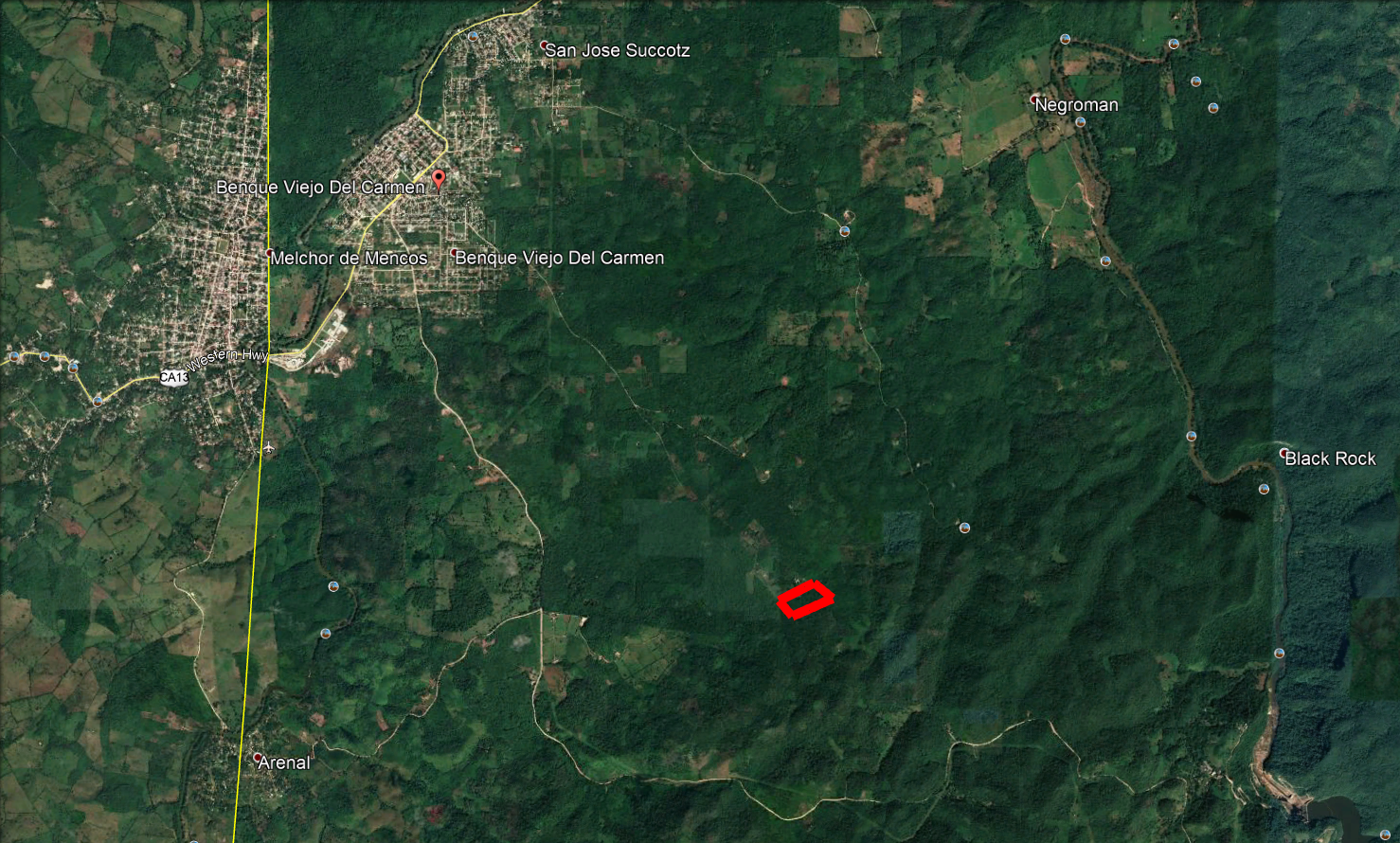 Aerial view of Belize land with building site marked in red.