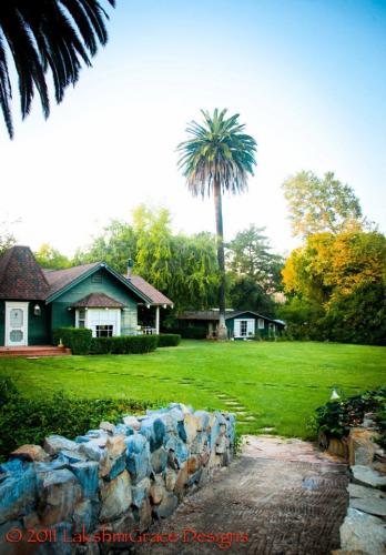 Scenic view of a lush green yard with palm trees and cozy houses in Vista, CA.
