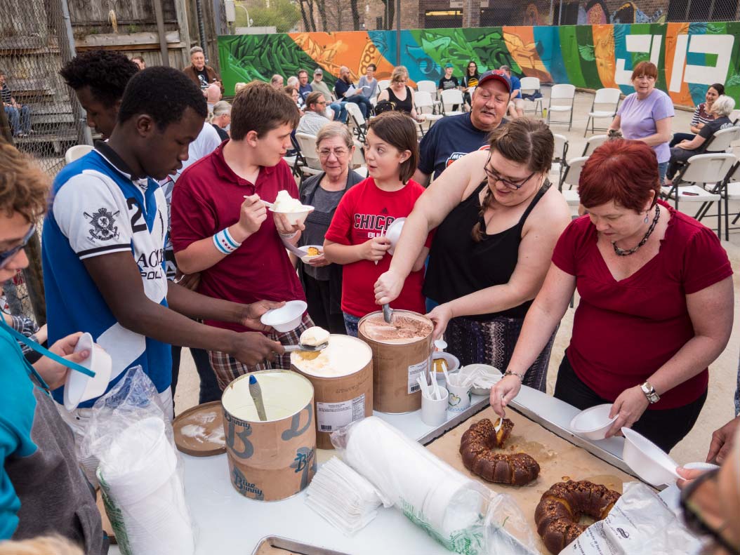 Community gathering enjoying food at Foundation for Intentional Community event.