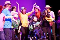 Group of diverse people performing on stage at Foundation for Intentional Community event.