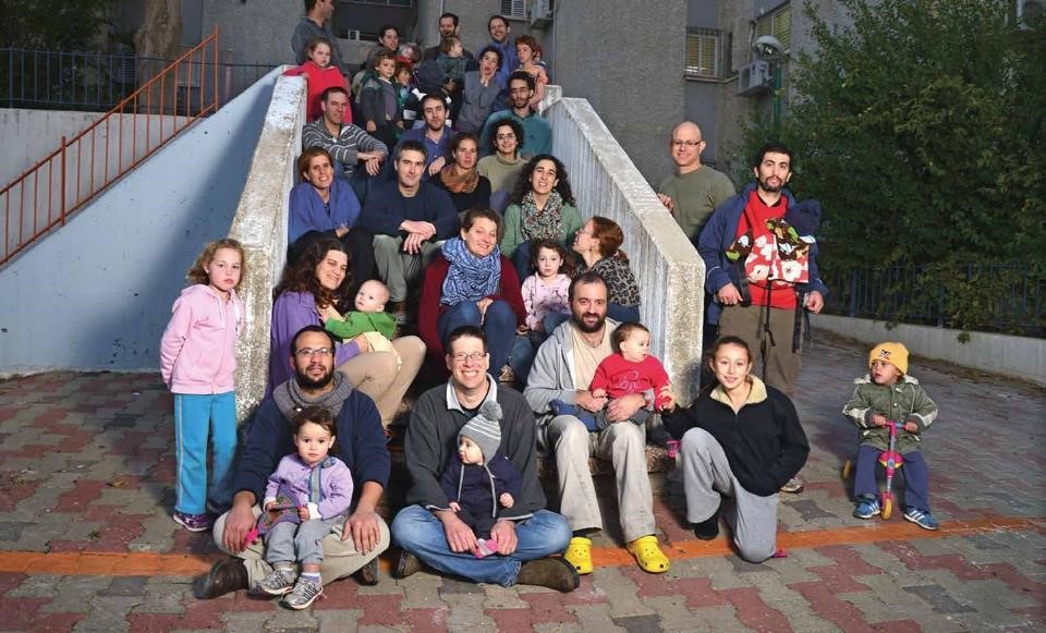 Group of diverse people including children and adults on outdoor stairs.
