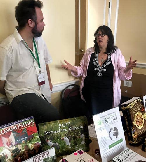Two people engaged in conversation at a community event table.