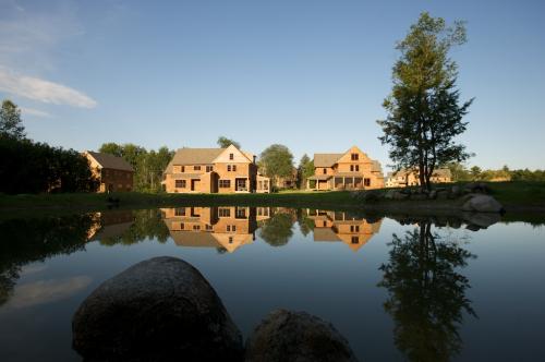 Newly constructed homes near a calm pond at Nubanusit Neighborhood & Farm.