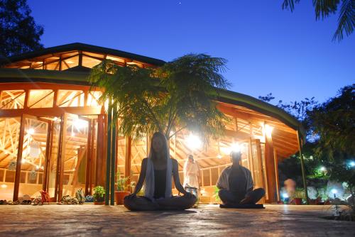 People meditating outside PachaMama Eco Village at sunset.