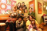Diverse group of people gathered in a cozy indoor setting for community event.