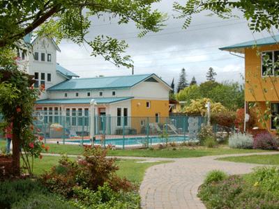 Colorful community buildings with a pool at Pleasant Hill Cohousing.