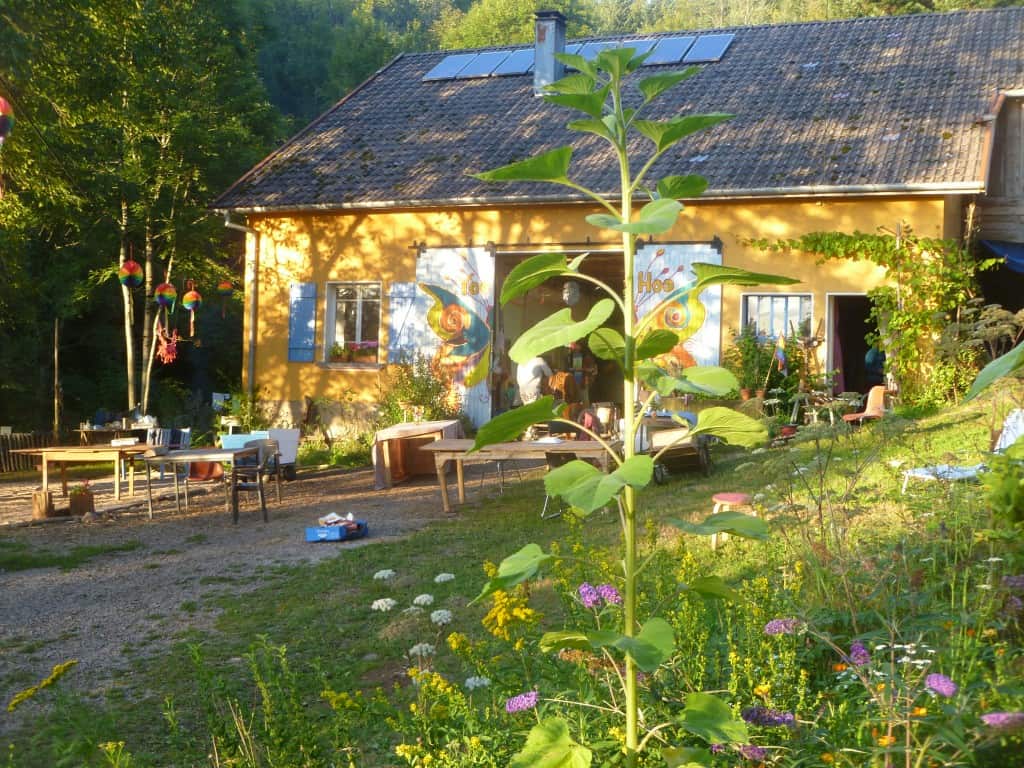 Rural community house with solar panels and outdoor seating area.