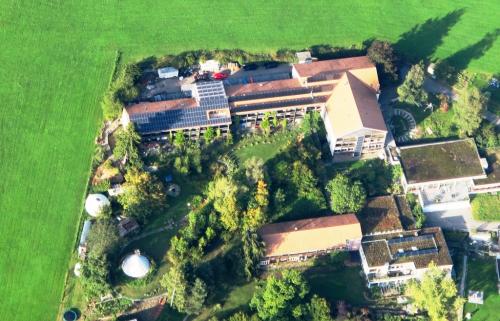 Aerial view of a community with green fields and multiple buildings surrounded by trees.