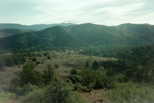 Scenic view of rolling green hills and mountains in a rural landscape.