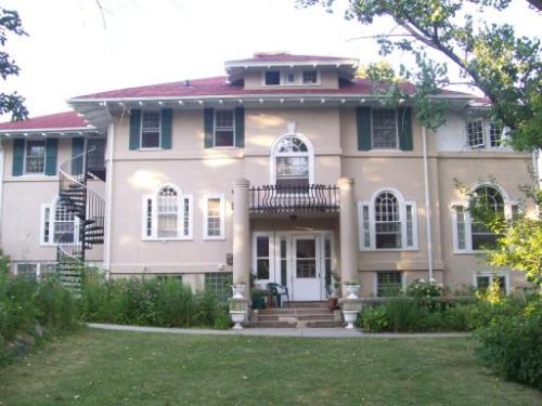 Historic mansion with lush garden and spiral staircase, in a community setting.