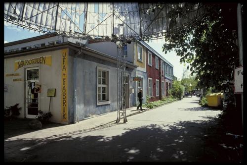 Exterior view of UFA-Fabrik with colorful buildings and a pedestrian on the street.