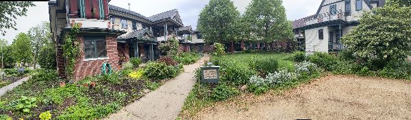 Community garden with pathways and residential buildings in a cohousing neighborhood.