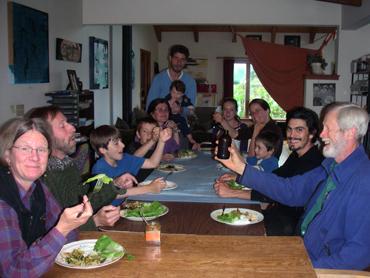 Group of diverse people enjoying a meal together at a long table.