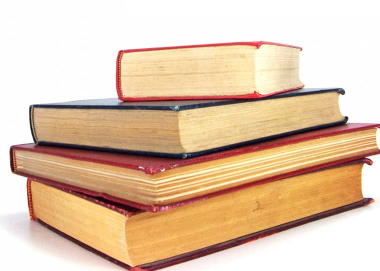 Stack of four hardcover books with red, black, and beige covers.