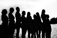 Group of diverse people standing outdoors in silhouette for community energy project.