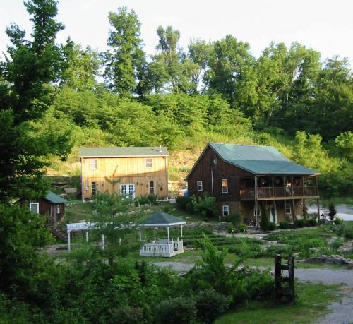 Scenic view of two wooden houses in a lush green community setting.