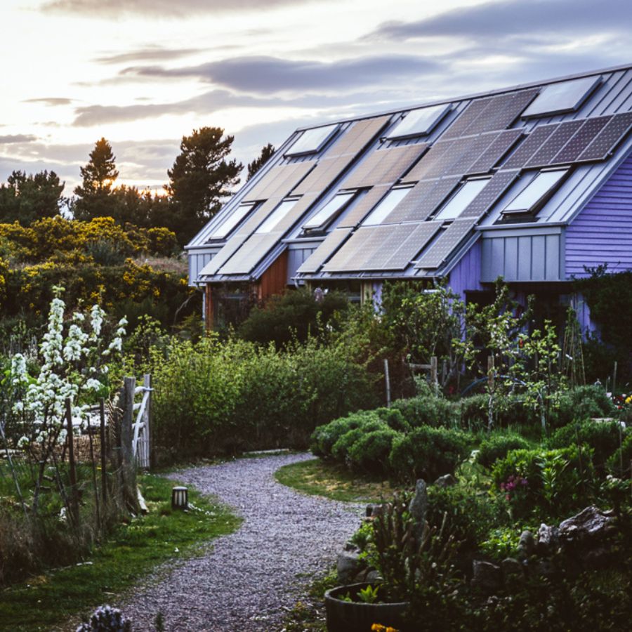 Community home with solar panels in a lush garden setting.