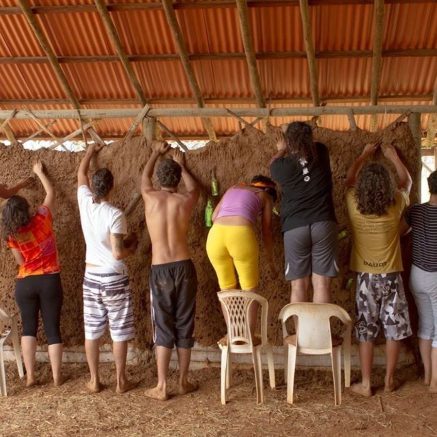 People working together to build a mud wall at an intentional community.